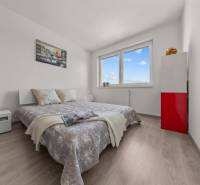 Bedroom in a 4-room apartment with a comfortable bed, white furniture, and modern decor.