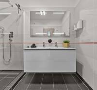Bathroom with a sink, shower, and mirror in a 4-room apartment.