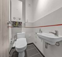 Bathroom in a 4-room apartment with a toilet, sink, and a boiler on the wall.
