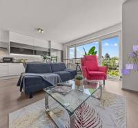 Living room with a sofa and an armchair in a 4-room apartment. Large windows with a view.