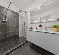 A bathroom in a 4-room apartment with a shower and a double sink.