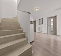 A staircase in a 4-room apartment with wooden flooring and white walls.