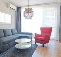 Living room with a comfortable sofa, a red armchair, and a television in a two-room apartment.