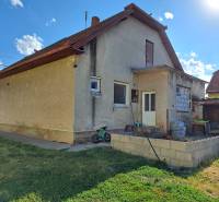 A family house in Kmeťovo with a terrace, garden, and stored items by the house.