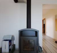 Wood-burning stove in a family house, minimalist design in a light interior.