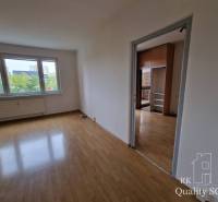 A spacious room with wooden flooring and large windows in a 4-room apartment.
