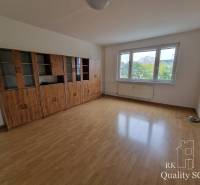 A spacious room with wooden floors and a large glass cabinet in a 4-room apartment.