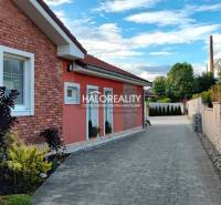 A family house in Kalinovo with a brick facade, a paved walkway, and a landscaped garden.