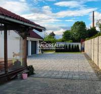 A family house in Kalinovo with a paved courtyard, terrace, and fencing.