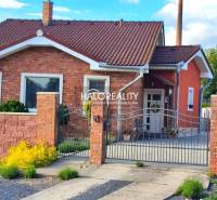 A family house in Kalinovo with a brick facade, decorative fence, and garden features.