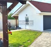 The exterior of a family house in Kalinovo with a lawn, terrace, and double garage.
