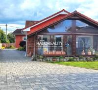A family house in Kalinovo with a paved driveway and a glassed-in veranda.