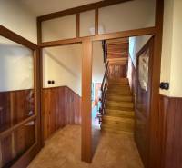 Wooden staircase and doors in a family house with paneled walls and tiles.