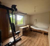 Exercise machine, bed, and desk in a room of a family house.