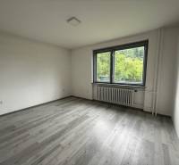 An empty room in a family house with a large window, light wooden floor.