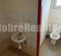 A restroom with a sink and a urinal in commercial premises.