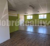 Interior of commercial premises with windows, flooring, and radiators.