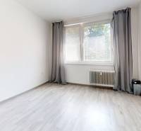 A room in a 2-room apartment with a light floor, a window, and gray curtains.