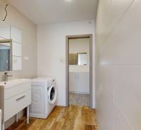 Bathroom with toilet, washing machine, and sink in a 2-room apartment.