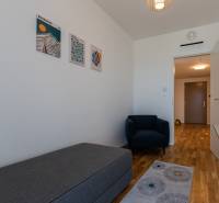 A room in a 3-room apartment with an armchair, laminate flooring, and wall paintings.
