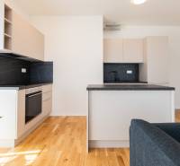 A kitchen with a black countertop and light cabinets in a 3-room apartment.