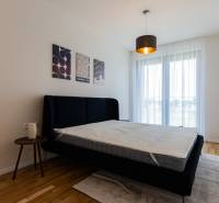 Bedroom with a bed and a nightstand, complemented by wall decorations.
