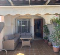 A family house in Santiago de la Ribera with a terrace, wooden furniture, and flower pots.