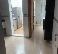 Hallway with entrance to the bathroom and kitchen in a family house, light tiles.