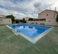 In Santiago de la Ribera, a courtyard of a family house with a swimming pool and benches is visible.