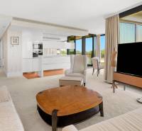 Living room in a 3-room apartment with a view of large windows and comfortable seating.