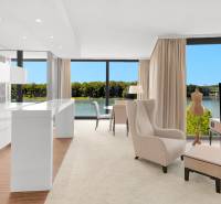 A bright living room with a view of the river in a 3-room apartment, equipped with a kitchen and a television.