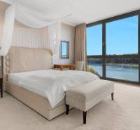 A bright bedroom in a 3-room apartment with a view of the river and vintage furniture.