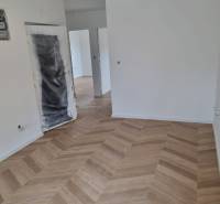 Unfinished space in a 4-room apartment with laid wooden flooring.