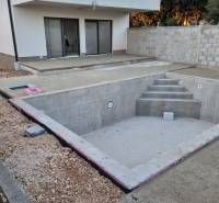 4-bedroom apartment with an unfinished pool in Mandre, terrace, and partially fenced plot.