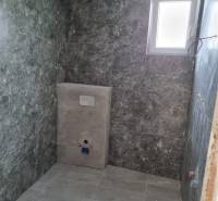 A bathroom with gray tiles and a window in a 4-room apartment.
