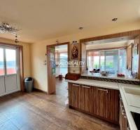 A kitchen in a family house with glass doors and a countertop with a wooden decor.