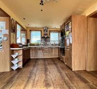 A kitchen in a family house with wooden cabinets and built-in appliances.