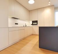 A kitchen in a 2-room apartment with white cabinets and seating at the counter.