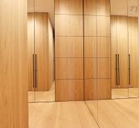 A wardrobe in a 2-room apartment with wooden cabinets and mirrors.