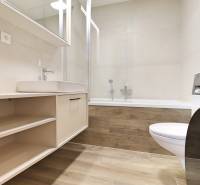 A bathroom with a bathtub and a washing machine in a 2-room apartment.