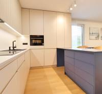 A modern kitchen in a 2-room apartment with an elegant countertop and light furniture.