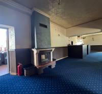 Interior of commercial space with a fireplace and a blue carpet.
