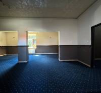 Interior of commercial premises with blue carpet and two rooms.