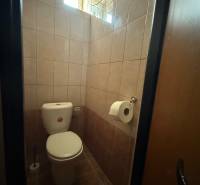 A restroom with tiled walls in commercial premises, with a window for natural light.
