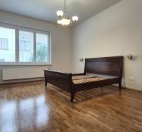 A room in a 5 or more bedroom apartment with a bed and wooden floor.