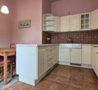 A kitchen with a wooden table and chairs in a five or more room apartment.
