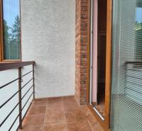 A balcony in a 5 or more room apartment with tiles and brick cladding.