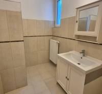 A bathroom with a bathtub and sink in a 5 or more room apartment in beige tones.