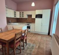 A kitchenette with a dining table, cabinets, and appliances in a 5 or more room apartment.
