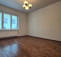 A spacious room with wooden flooring and a large window in a 5 or more room apartment.